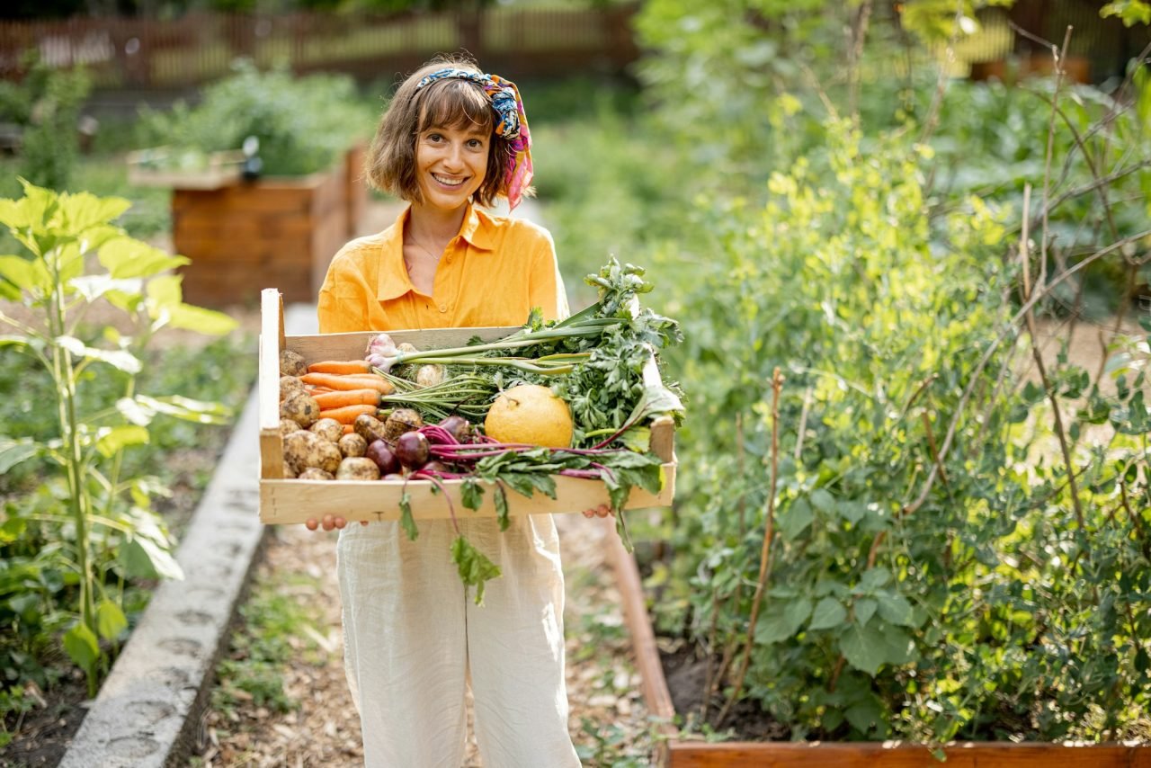 young-farmer-with-freshly-picked-vegetables-at-garden.jpg
